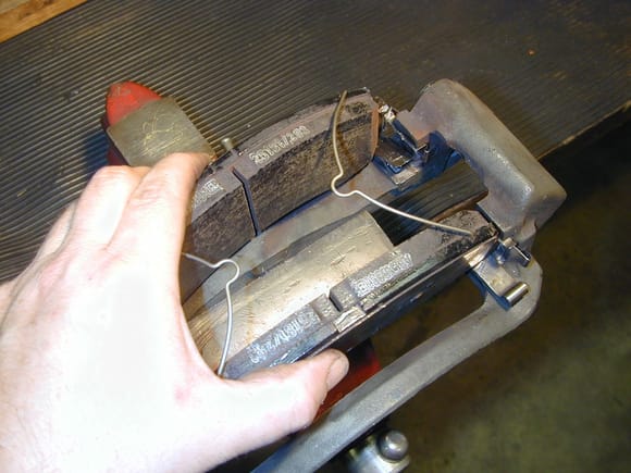 The caliper assembly should be double checked for freedom of movement before being installed on the vehicle.  The "Wishbone" V-Springs were a Akebono addition around late 2001 if memory serves.  In the US patent it describes these as a noise abatement improvement, but the Akebono Australian site describes them as what they were, a device to reduce pad contact to the rotors and minimize rotor DTV.  The 2005+ TRW caliper design uses slippers to do this instead.