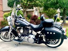 The Harley Signature Series Seat did the trick for me. It’s wide at the back, a little narrower in front and sits you deep in the bike with lots of back support. A nice fat passenger cushion too. I got mine on eBay used once (didn’t fit the original purchaser) for a third the new price. Not a scratch on it. 
