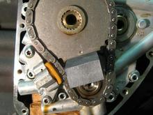 Cam cover removed (only a bit of oil is lost). Used a lock tool to remove cam/crank sprocket nuts (you can also leave motor in gear with rear wheel on floor to keep sprockets from turning).