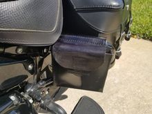 The Jiffy Stand Puck "Holster" hung on the left side saddle bag guard