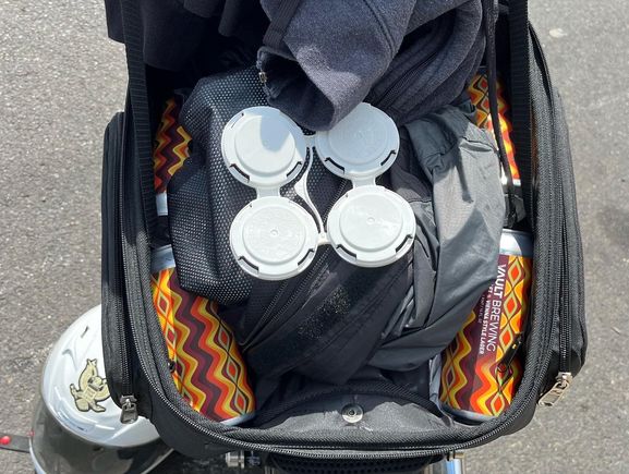 Even with a rain liner, two water thermoses, and a totally unnecessary hoody, I fit 4 large cans of beer with plenty of room to spare. Did not mess with the feel of the bike at all. 