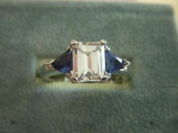 Emerald cut diamond with trillion blue saphires set in platinum