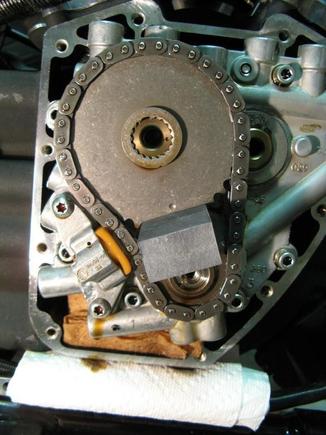 Cam cover removed (only a bit of oil is lost). Used a lock tool to remove cam/crank sprocket nuts (you can also leave motor in gear with rear wheel on floor to keep sprockets from turning).