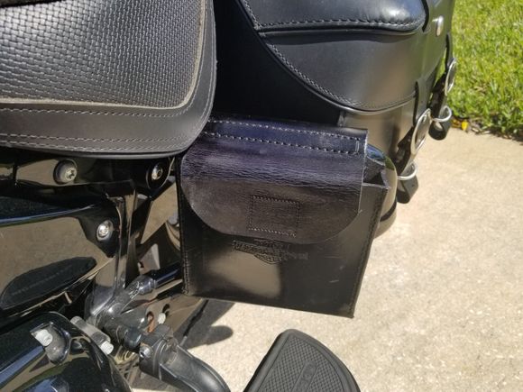 The Jiffy Stand Puck "Holster" hung on the left side saddle bag guard