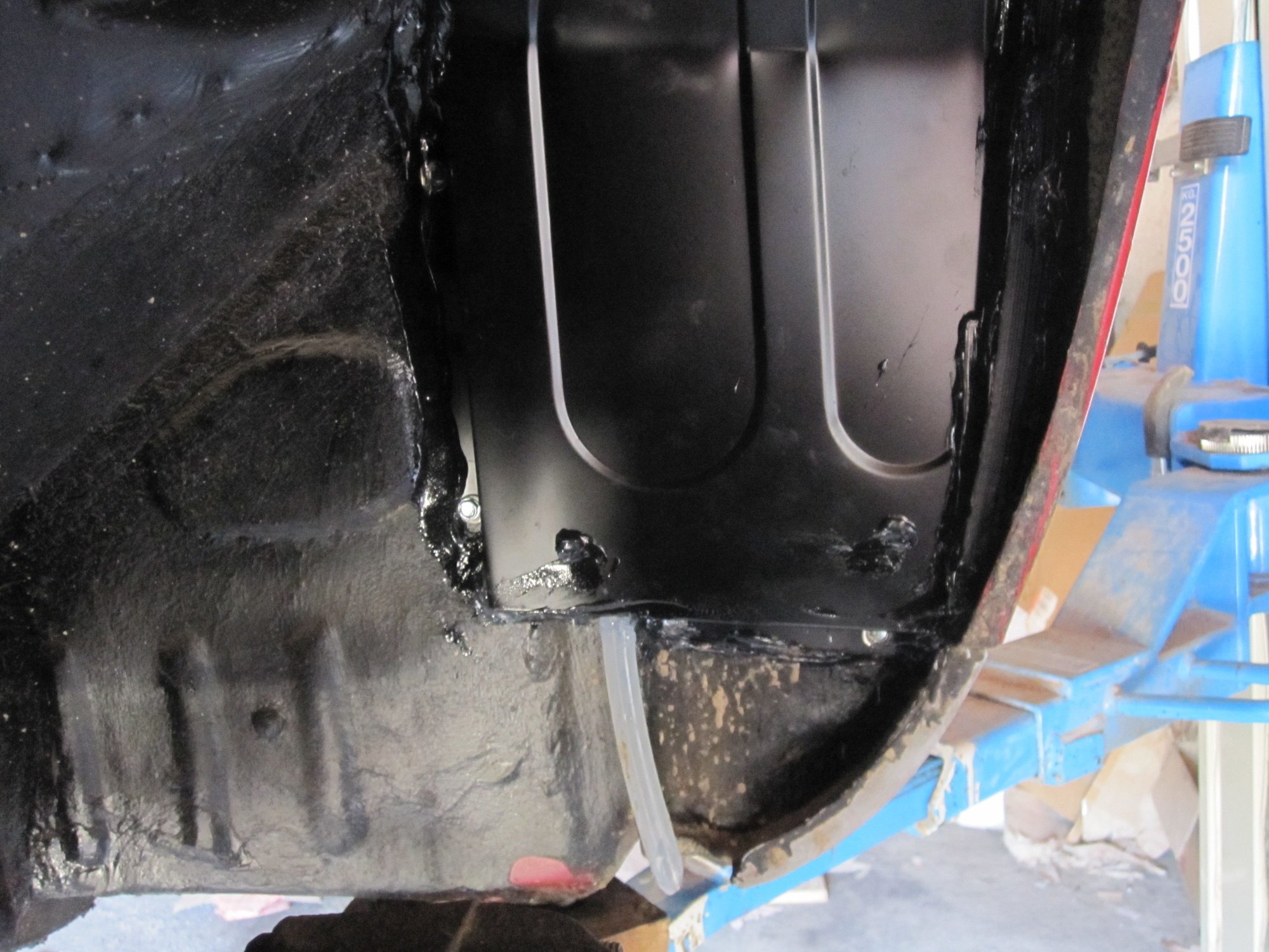 drain emerges from bottom of wheelarch baffle