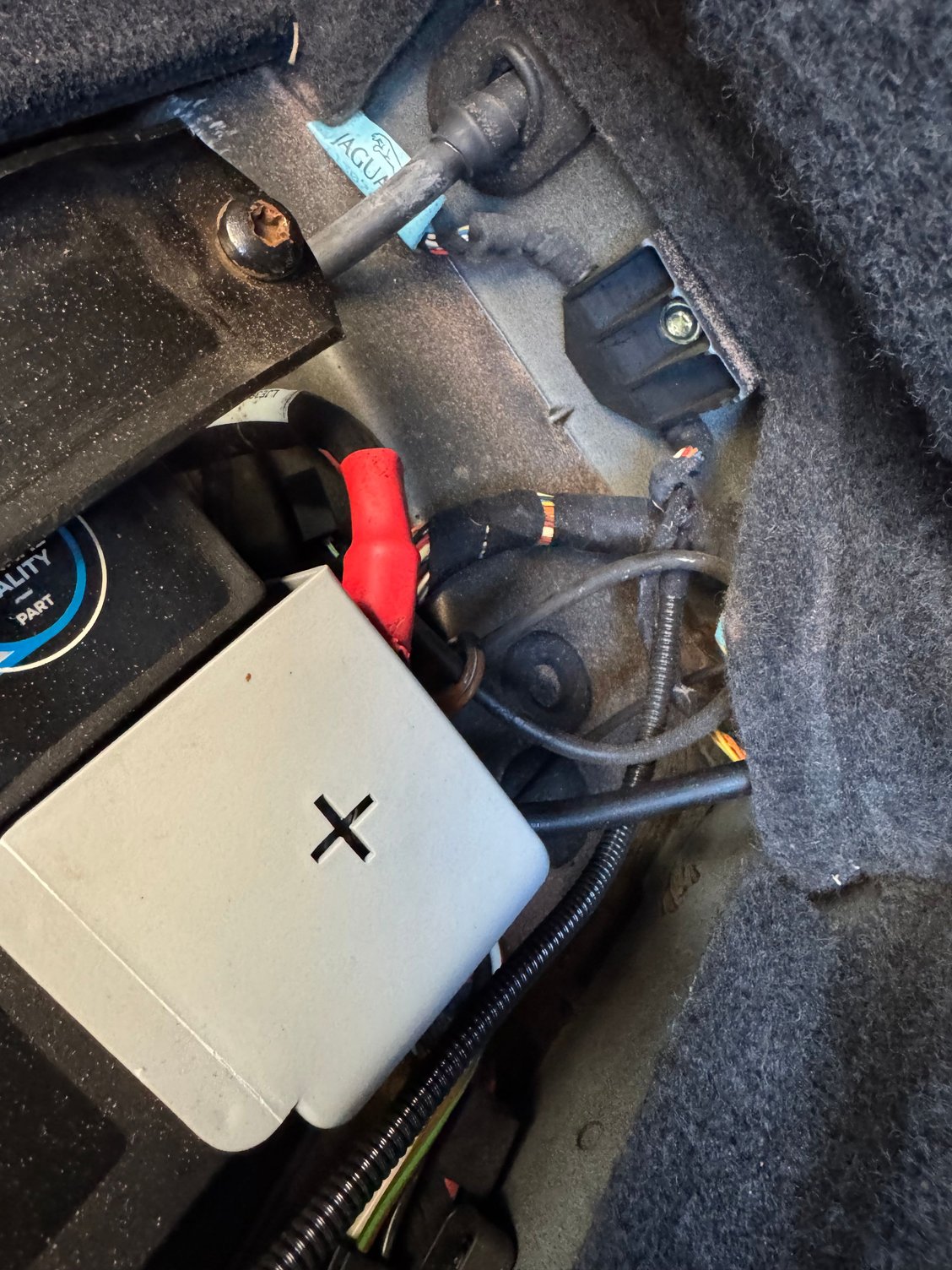 Goes through at the back of the battery compartment 