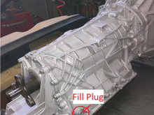 Fill plug located on the back right of the transmission