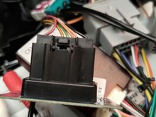 The black connector up front is the harness from the car, going to the connection of the head unit.   Disconnecting and reconnecting the small connector with the black and green wire, will turn the hazard lights on.  Then doing it again will turn them off.   