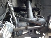 Using a tool to break open the upper ball joint to vertical link