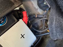 Goes through at the back of the battery compartment 