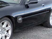As you can see in the highlighted area, the Jaguar badge has been pried off the silver backing oval which is still attached to the front quarter panel.
