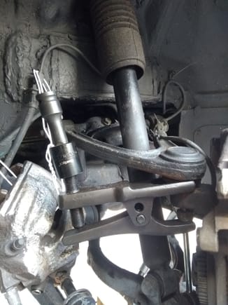 Using a tool to break open the upper ball joint to vertical link