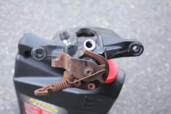 Top shot of the caliper.  Notice how the e-brake arm is nice and rusty.  You will see later where this rust has caused this to bind up.  If you see the post at the 4 o'clock position on the lever, that should be up against the bolt at the 6 o'clock position.  Obviously frozen.