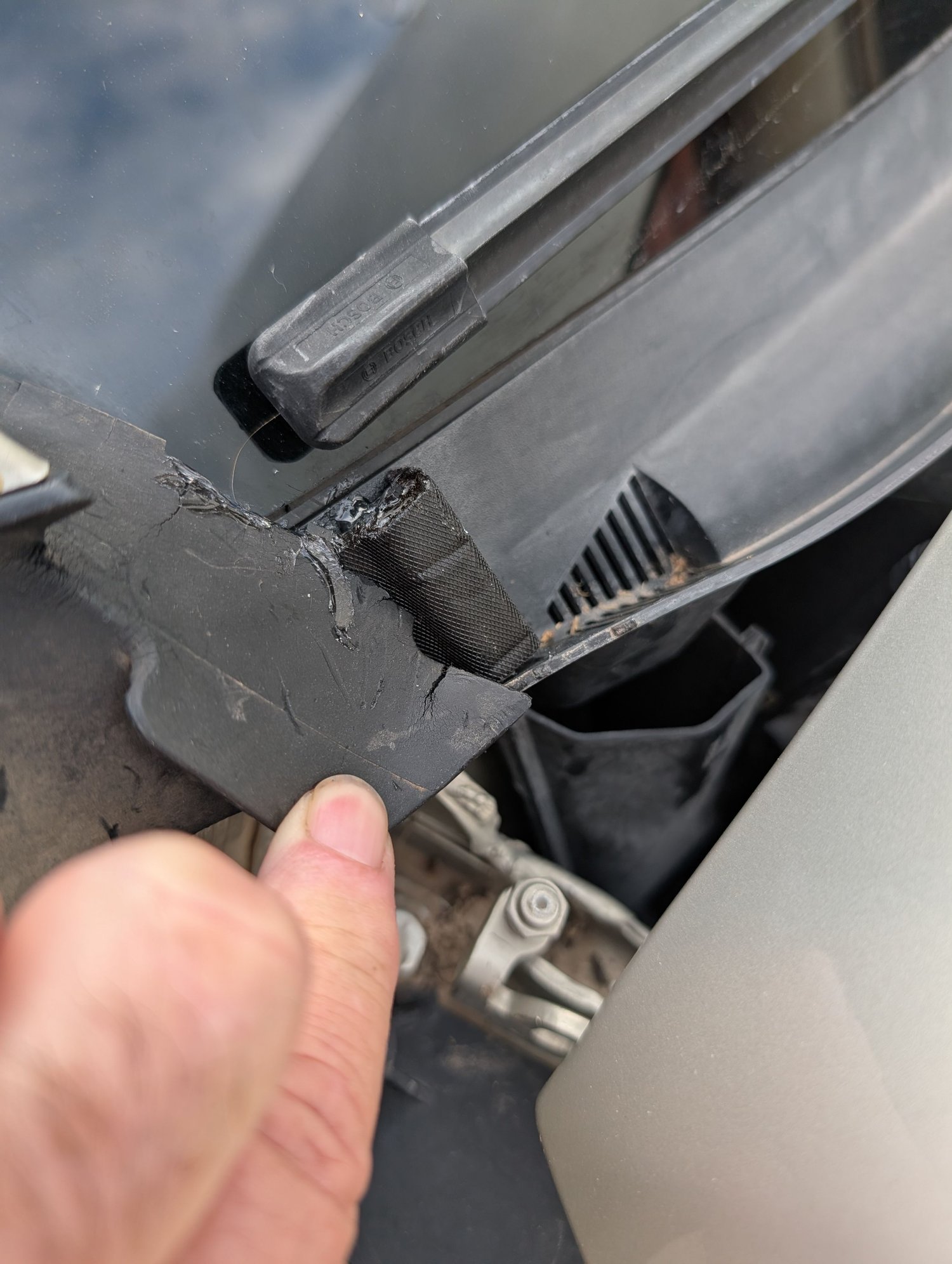 Located at bottom of windshield on passenger side.