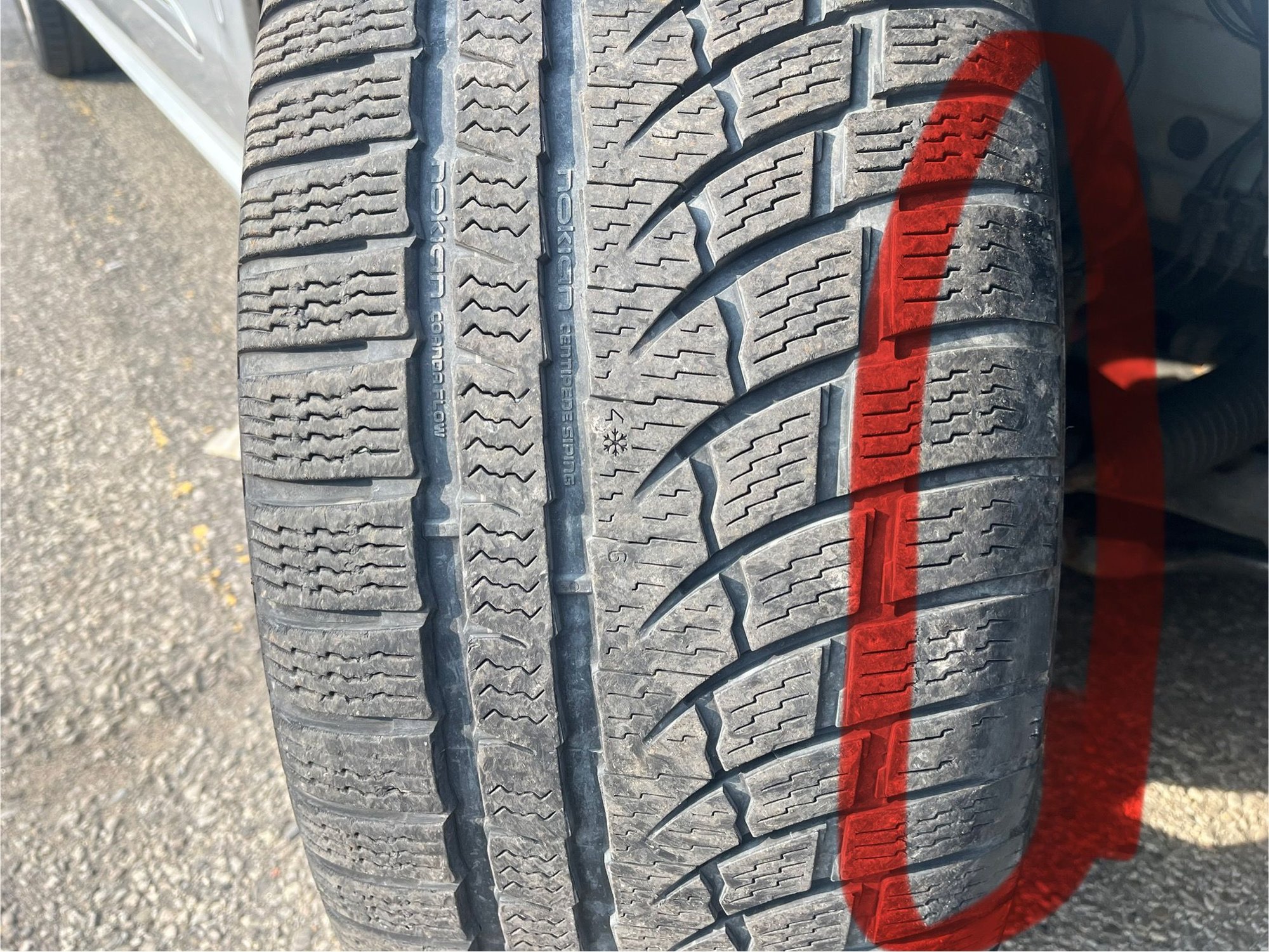 Right side tire - highlighted red showing wear on inside edge only. 