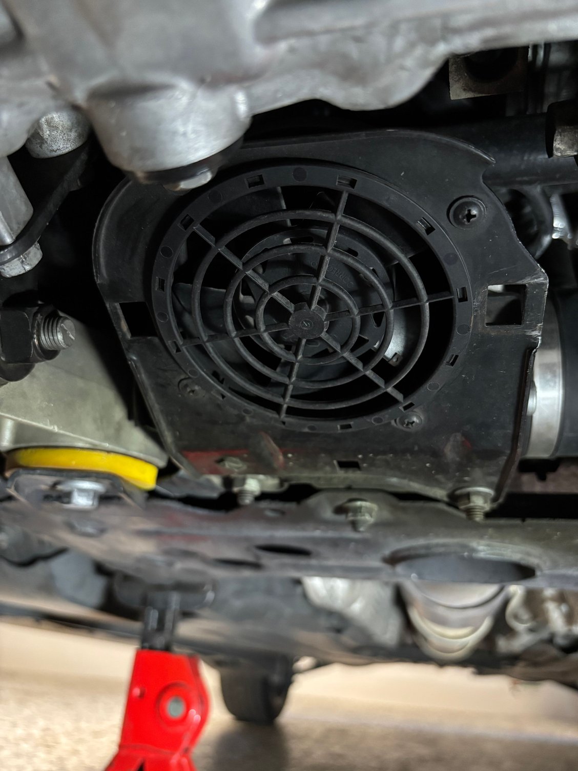 Power steering fan housing with openings for C-clip nuts.