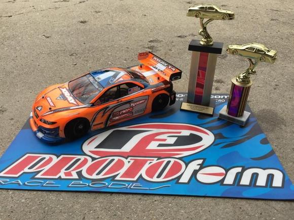 My Xray and its Invitational trophies!  I'm running an ORCA TX 17.5, Orion R10 Pro US Stock Spec ESC, Savox 1252 low-profile servo, Reedy 5500 60C lipo, Protoform Mazda Speed6 body, and Contact RC foam tires.  Controlled by a KO Propo EX1-KIY