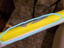 The black is showing through the yellow paint on the leading edge