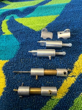 Here are the old cylinders. Glued together (unserviceable), 1/16 soft wire rods (!) etc. New cylinders 1/8 hardened steel rods, MUCH bigger pistons etc.