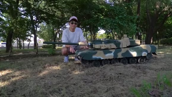The photo shows the 2022 1/5 scale K2 Black Panther tank with Korean comedian Guen Jae-kwan.