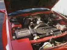 Overview of engine bay containing all stock parts. I don't desire to race or squeeze torque or extra hp's. 13b is a rebuild by  Kevin at Rotary Resurrection in nearby Morristown TN! A remarkable job. He built both rotors, replaced irons and all seals. He installed a banjo bolt for fuel pulsation elimination. He also implemented a fuel cutoff switch positioned under the ignition! No more flooding and fuse-pulling and endless cranking.