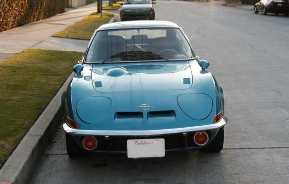 What's that bump on the hood?  The air cleaner sits below it.

How do those lights work?  They &quot;roll&quot; over 180 degrees from right to left.  The operation is completely manual, with a big lever on the center console that you force forward to rotate the lights up, yank back on to rotate them down.

Hate the big license plate! Must have for CA.