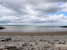 View on the beach. Notice the textures. Rocks, sand, different colors water, and on to the clouds and sky