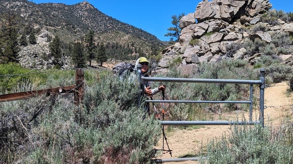 ^6-15-2024.  Hiker "Spicy" (Becky) going through the last gate before arriving at the Kennedy Meadows General Store.  She hiked 700 miles on the Pacific Crest Trail to get here.