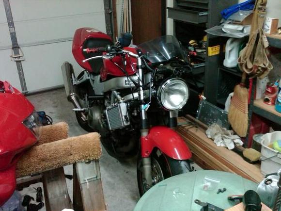 Made it fairingless on the front. Found a nice round headlight for a vintage sort of look. I also cut and modified the front windshield with a hot knife to what it is now. 
 Haven't decided what I'm going to do with the radiators. I've painted the metal mesh-work covering them black. Not seen in this picture.