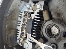 Remove the three bolts here and the but on the back that screws to the battery lug.