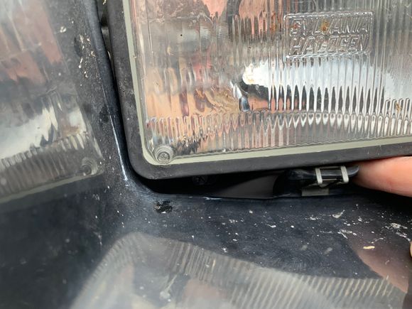 Plastic piece, I assume ticks under the eye pocket to raise it up to meet the bottom of the headlight.
