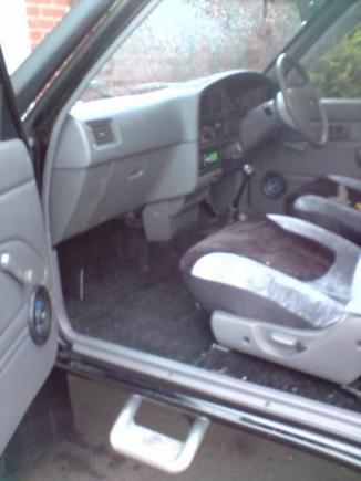 Interior, recently fitted luxury of a carpet in black, and seat covers, soon to be heated electric leather seats from a donor vehicle in a salvage yard someplace, and a leather and chrome steering wheel also to be added