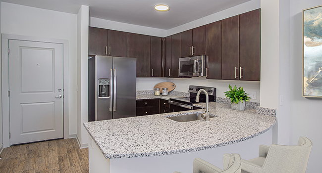 Beautifully renovated kitchens feature granite countertops and stainless steel appliances